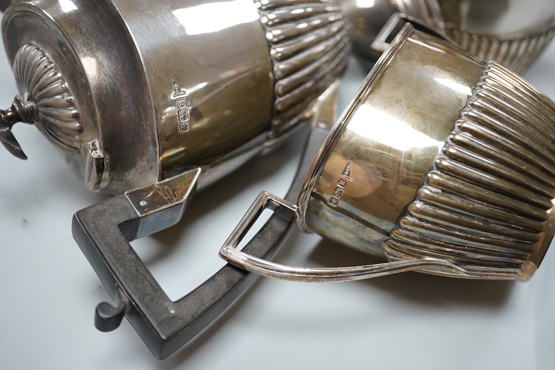 A George V demi fluted silver four piece oval tea set, comprising a teapot, hot water jug, cream jug and sugar bowl, Walker & Hall, 1910/11/12, gross weight 49oz.